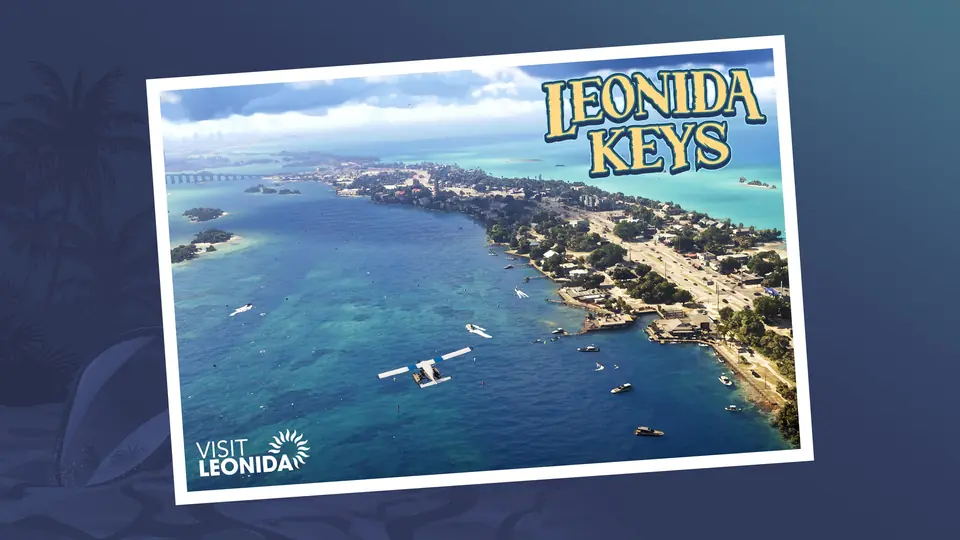 Postal oficial de los Leonida Keys: vista aérea de una isla alargada entre aguas turquesa, con barcos y una avioneta.