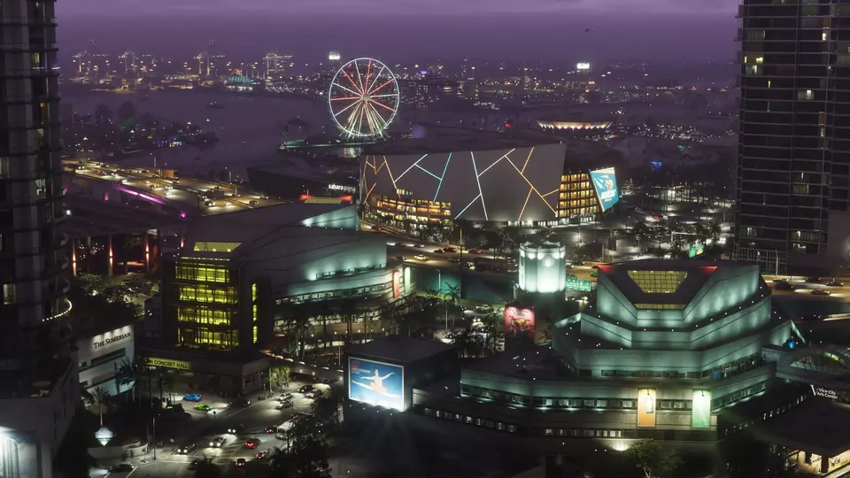 Vice City de noche desde el aire: rascacielos iluminados, una noria y el puerto.