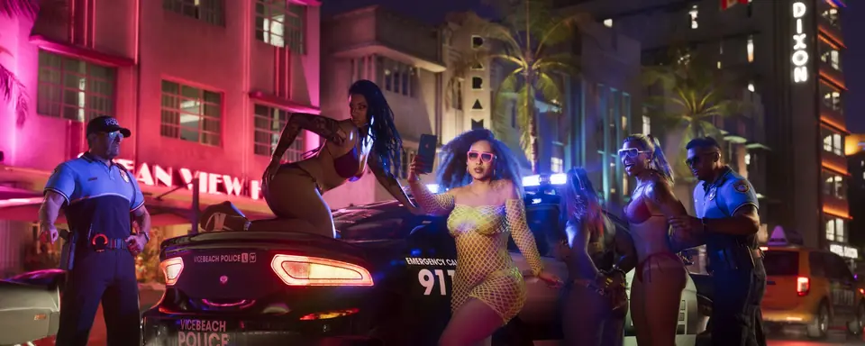 Una calle de Vice City de noche, con letreros de neón, un deportivo y policías junto a un grupo de gente.
