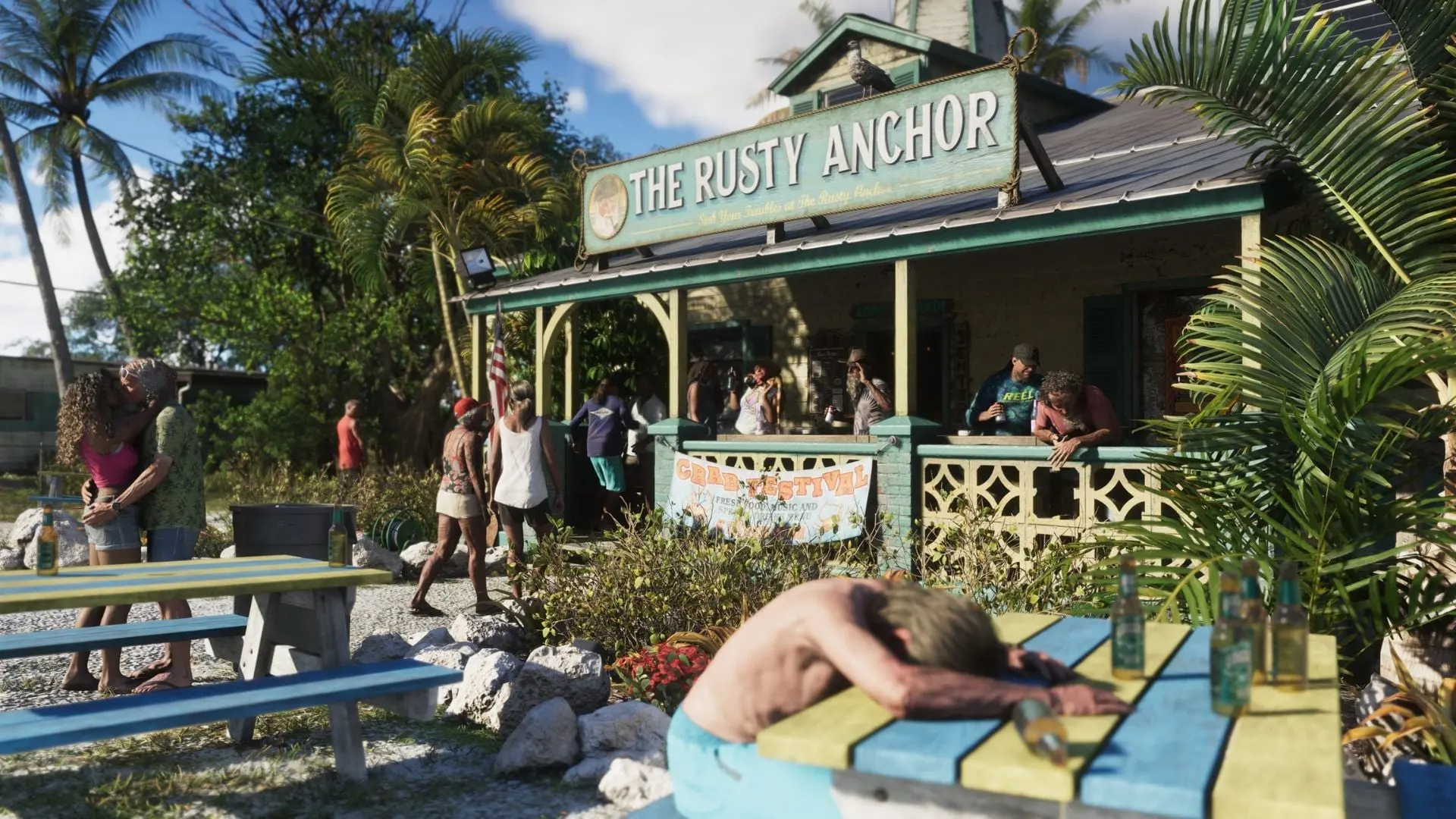 Captura de GTA VI: clientes en la terraza del bar The Rusty Anchor, con un hombre dormido sobre una mesa llena de botellas.