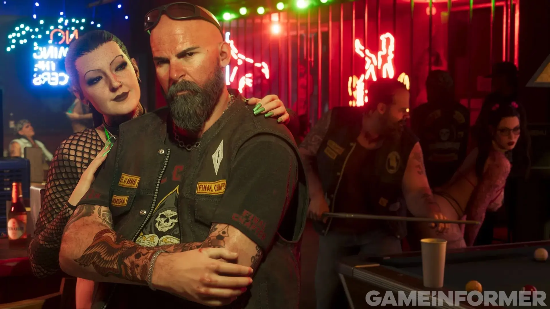 A bearded biker in a vest hugs a woman in fishnets inside a neon-lit biker bar.
