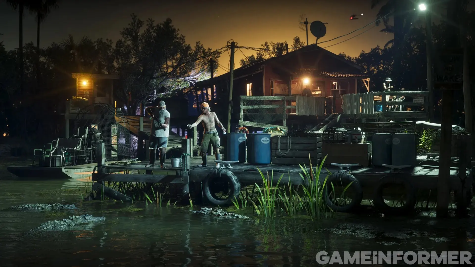 A wooden swamp dock at night, with two men next to drums, alligators in the water and a lit house behind them.