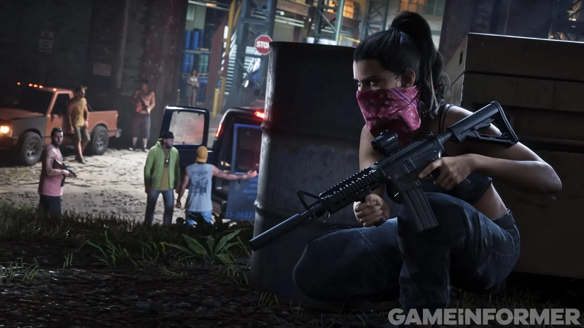 Lucia, with a red bandana over her face, crouches behind crates with an assault rifle while several armed men keep watch at night.