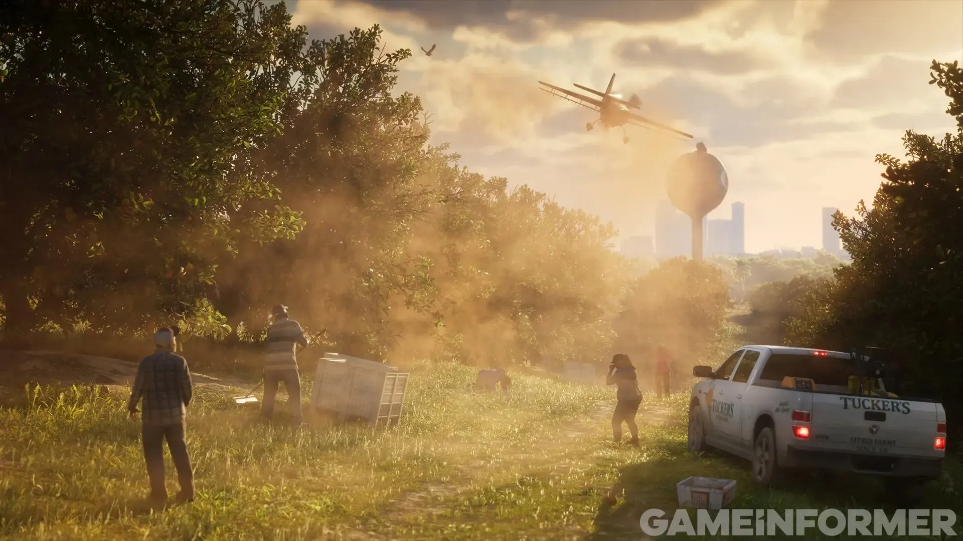 A crop duster flies low over a dusty field where several people crouch by a white pickup, with a water tower and the city in the distance.