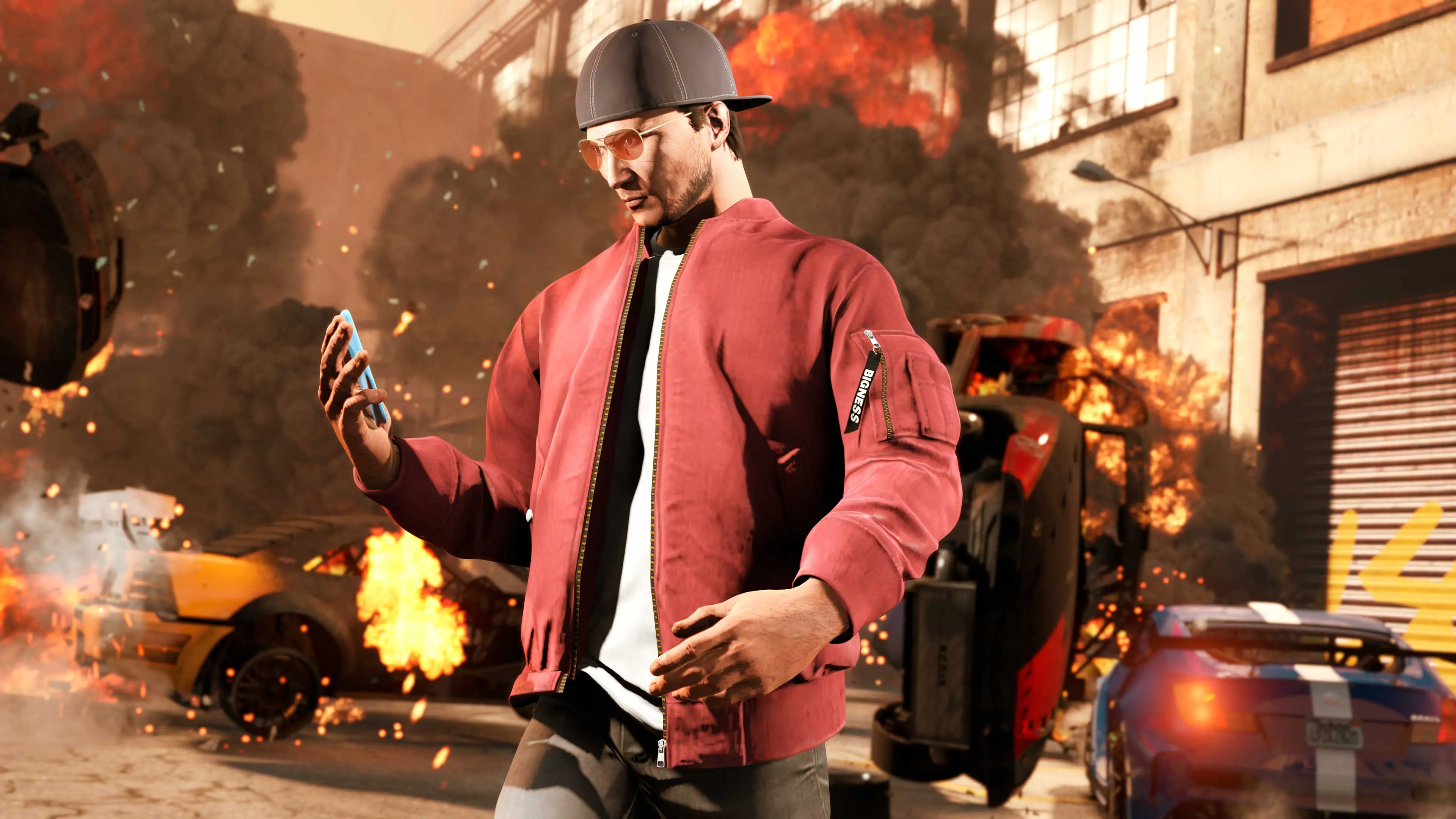 A GTA Online character in a red jacket looks at their phone as cars burn in the street behind them.